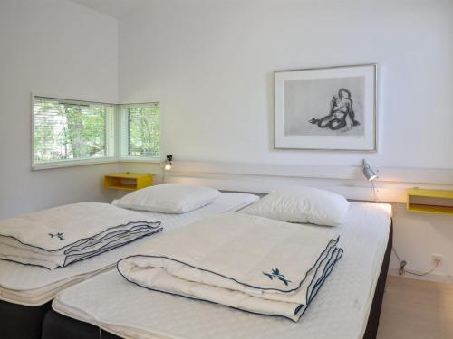 two beds in a room with two windows at Holiday Home Muriel - 150m from the sea by Interhome in Neksø