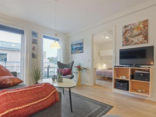 a living room with a couch and a tv at Apartment Gjuro - 50m from the sea by Interhome in Allinge