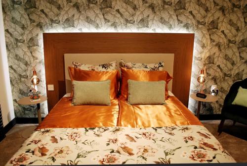 a bedroom with a large bed with orange sheets and pillows at "The Church Fields Studio - Dream Stay" Rust nabij natuur in Brunssum