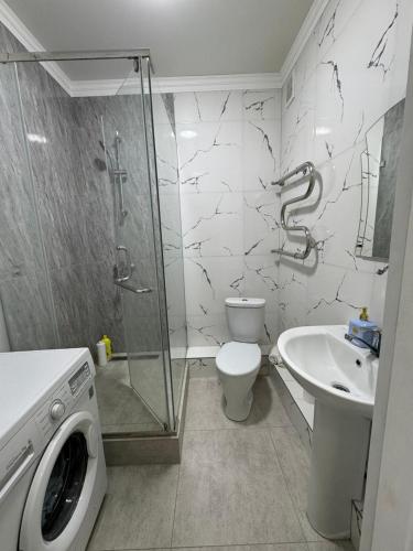 a bathroom with a shower toilet and a sink at Жк Райымбек in Almaty