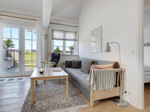 a living room with a couch and a table at Apartment Antine - 6km from the sea by Interhome in Åkirkeby