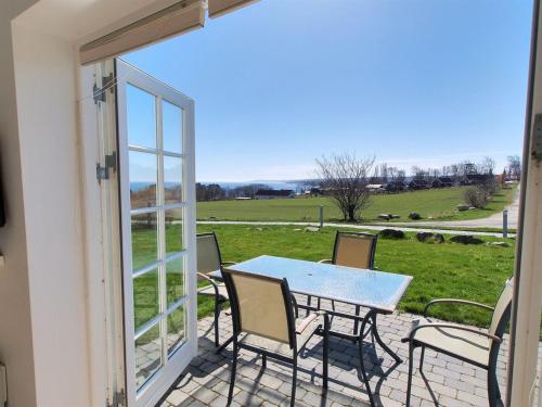 a table and chairs on a patio with a view of a field at Apartment Tinne - 400m from the sea by Interhome in Allinge