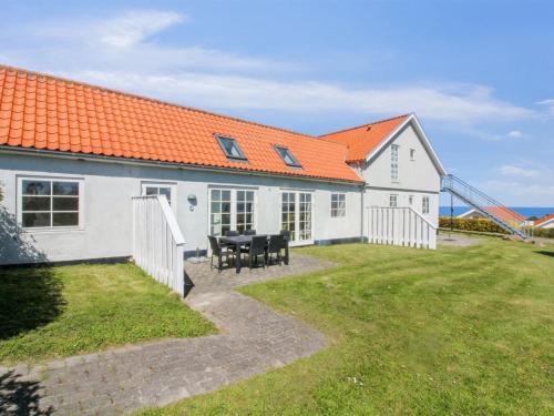 a white house with an orange roof and a table at Apartment Tinne - 400m from the sea by Interhome in Allinge