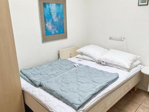 a bed with a blue blanket on top of it at Apartment Erica - 6km from the sea by Interhome in Åkirkeby