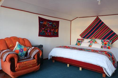 プーノにあるTiticaca Lodge Flotanteのベッドと椅子のある寝室