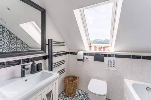 a bathroom with a sink and a toilet and a mirror at Herczeg-Fekete Cottage Birtokközpont in Simontornya