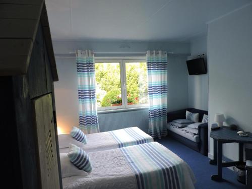 a small bedroom with a bed and a window at Hotel Restaurant Aux Sapins in Thann