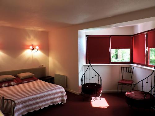 1 dormitorio con cama y ventana roja en Hotel Restaurant Aux Sapins, en Thann