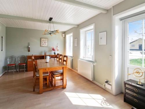 a dining room with a wooden table and chairs at Holiday Home Nilia - 3-5km from the sea by Interhome in Østermarie