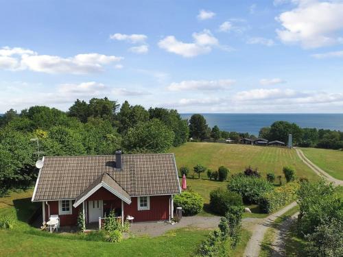 a red house on a hill with the ocean in the background at Holiday Home Spurgh - 250m from the sea by Interhome in Allinge