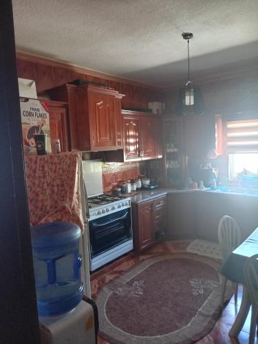 una cucina con mobili in legno e una stufa di Sky apartment ad Amman