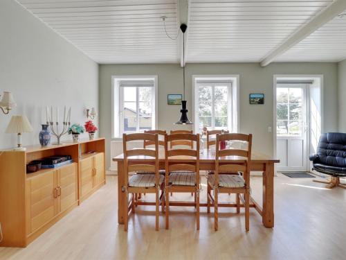 a dining room with a wooden table and chairs at Holiday Home Nilia - 3-5km from the sea by Interhome in Østermarie