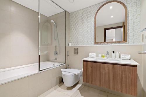 a bathroom with a toilet and a tub and a sink at FIRST CLAS 1BR Creek Beach , Lagoon Access in Dubai