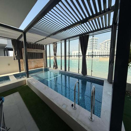 a swimming pool with a view of the water at Luxury 5BR Villa Private Pool & Beach Access in Sharjah