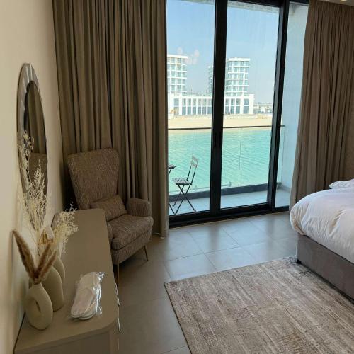 a hotel room with a bedroom with a view of the ocean at Luxury 5BR Villa Private Pool & Beach Access in Sharjah