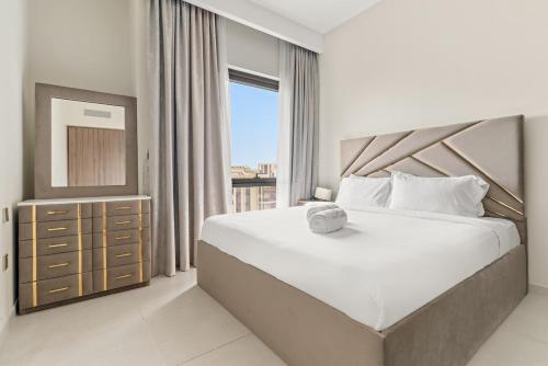 a bedroom with a large bed and a window at FIRST CLAS 1BR Creek Beach , Lagoon Access in Dubai