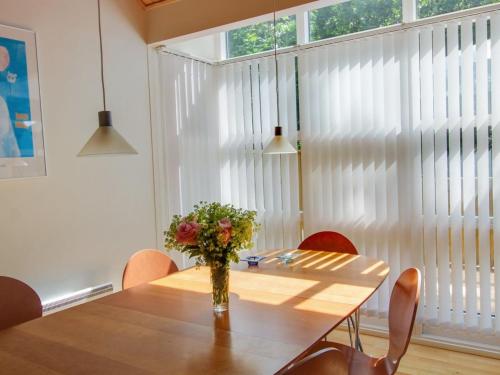 a dining room table with a vase of flowers on it at Holiday Home Dilan - 600m from the sea by Interhome in Hasle