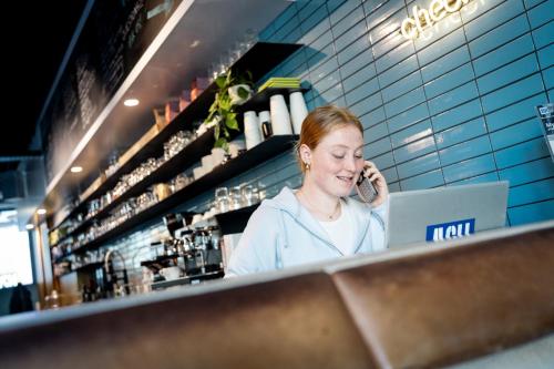 a woman talking on a cell phone behind a counter at The ASH in Antwerp