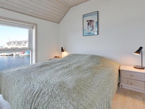 a white bedroom with a bed and a window at Holiday Home Eija - 5m from the sea by Interhome in Hasle