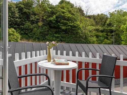 a table with two chairs and a vase of flowers on a patio at Holiday Home Eija - 5m from the sea by Interhome in Hasle