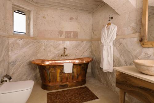 a bathroom with a wooden tub and a sink at Cappadocia Cave Suites Adult Only in Goreme