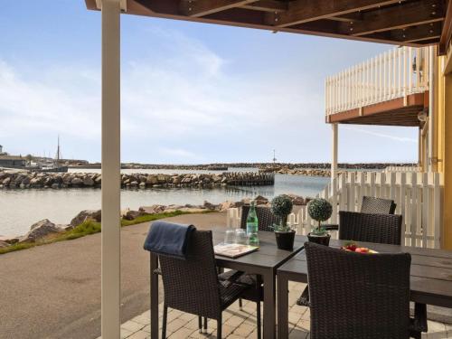 a table and chairs on a patio with a view of the water at Holiday Home Fridhild - 10m from the sea by Interhome in Hasle