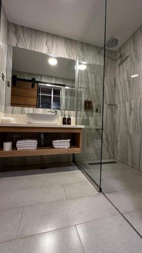 a bathroom with a shower and a large mirror at Fairway Boutique Hotel - Kampala, Uganda in Kampala