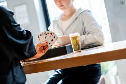 a woman sitting at a table with a book and a glass of beer at The ASH in Antwerp
