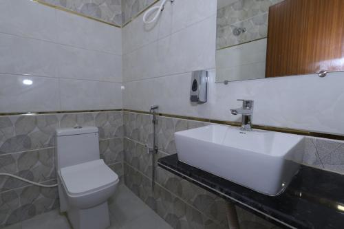 un bagno con un lavandino bianco e un water di Raghavam Hotel by Stay Bliss Retreats a Ayodhya
