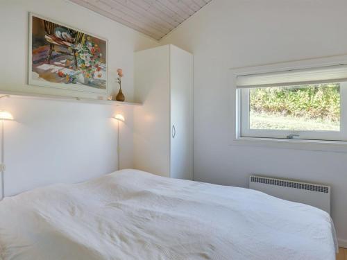 a white bedroom with a bed and a window at Holiday Home Tjelle - 300m from the sea by Interhome in Allinge
