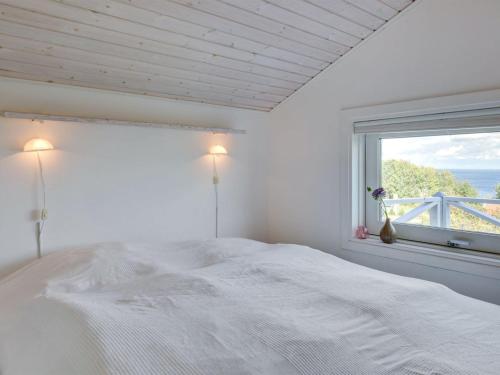 a white bedroom with a large bed and a window at Holiday Home Tjelle - 300m from the sea by Interhome in Allinge