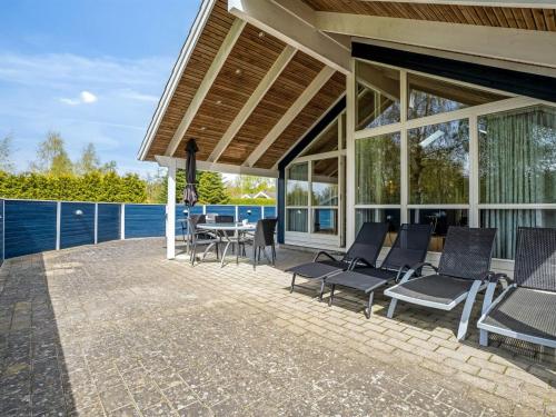 a patio with chairs and a table on a house at Holiday Home Alger - 800m from the sea by Interhome in Marielyst