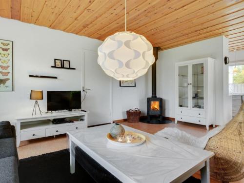 a living room with a table and a fireplace at Holiday Home Arnulf - 400m from the sea by Interhome in Marielyst