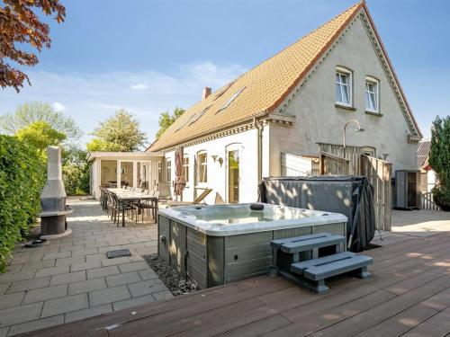 a hot tub on a patio in front of a house at Holiday Home Thorward - 1-5km from the sea by Interhome in Idestrup