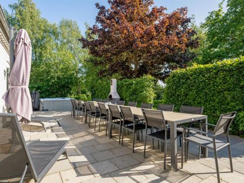 a row of tables and chairs with an umbrella at Holiday Home Thorward - 1-5km from the sea by Interhome in Idestrup