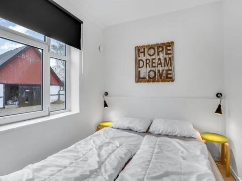 a bedroom with a bed and a sign on the wall at Holiday Home Thorward - 1-5km from the sea by Interhome in Idestrup