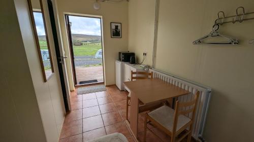a dining room with a table and a table and chairs at Staðarhóll Guesthouse Room B in Þingeyjarsveit