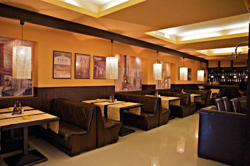 a restaurant with tables and chairs in a room at Hotel Serdica in Silistra