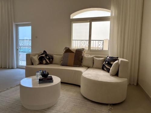 a living room with a couch and a coffee table at Beach Front 03 bedroom villa plus maid room in Al Ḩamrīyah