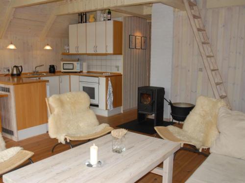 a living room with a table and chairs and a stove at Holiday Home Kalv - 75m from the sea by Interhome in Østerby