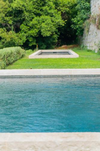 a swimming pool with blue water in a yard at Domaine de la Cascade Parfumée in Grasse