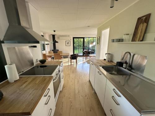 a kitchen with white cabinets and a wooden floor at Holiday Home Ady - 150m from the sea by Interhome in Augustenborg