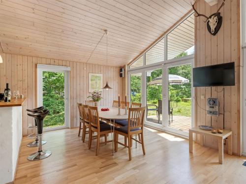 a kitchen and dining room with a table and chairs at Holiday Home Hertta - 200m from the sea by Interhome in Marielyst