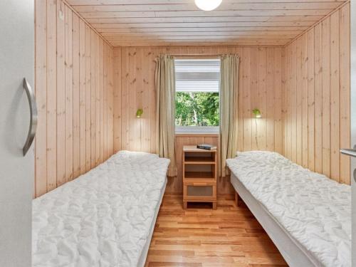 a bedroom with two beds and a window at Holiday Home Hertta - 200m from the sea by Interhome in Marielyst