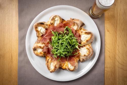 a plate of food with meat and greens on it at Hotel Sonne St. Moritz 3* Superior in St. Moritz