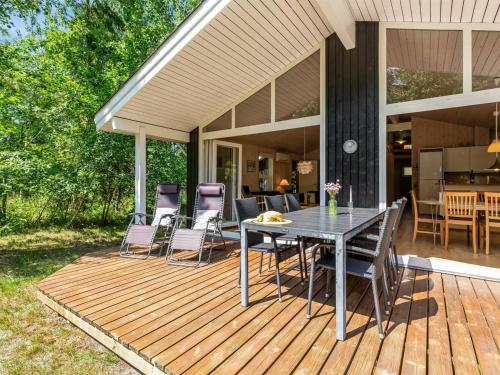 a wooden deck with a table and chairs on it at Holiday Home Hertta - 200m from the sea by Interhome in Marielyst