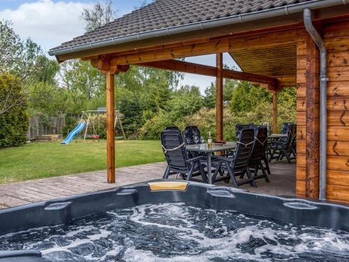 una vasca idromassaggio in un patio con tavolo e sedie di Holiday Home Dora - 180m from the sea by Interhome a Bøtø By