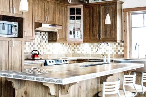 a kitchen with wooden cabinets and a large kitchen island at Chalet Boreal Mont-Blanc in Mont-Blanc