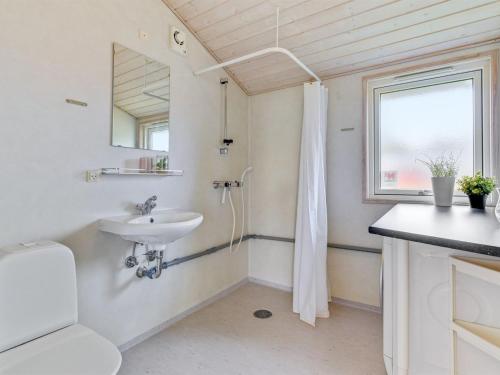 a bathroom with a sink and a toilet and a mirror at Holiday Home Helga - 100m from the sea by Interhome in Mommark
