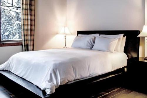a bedroom with a large bed with white sheets and pillows at Chalet Boreal Mont-Blanc in Mont-Blanc
